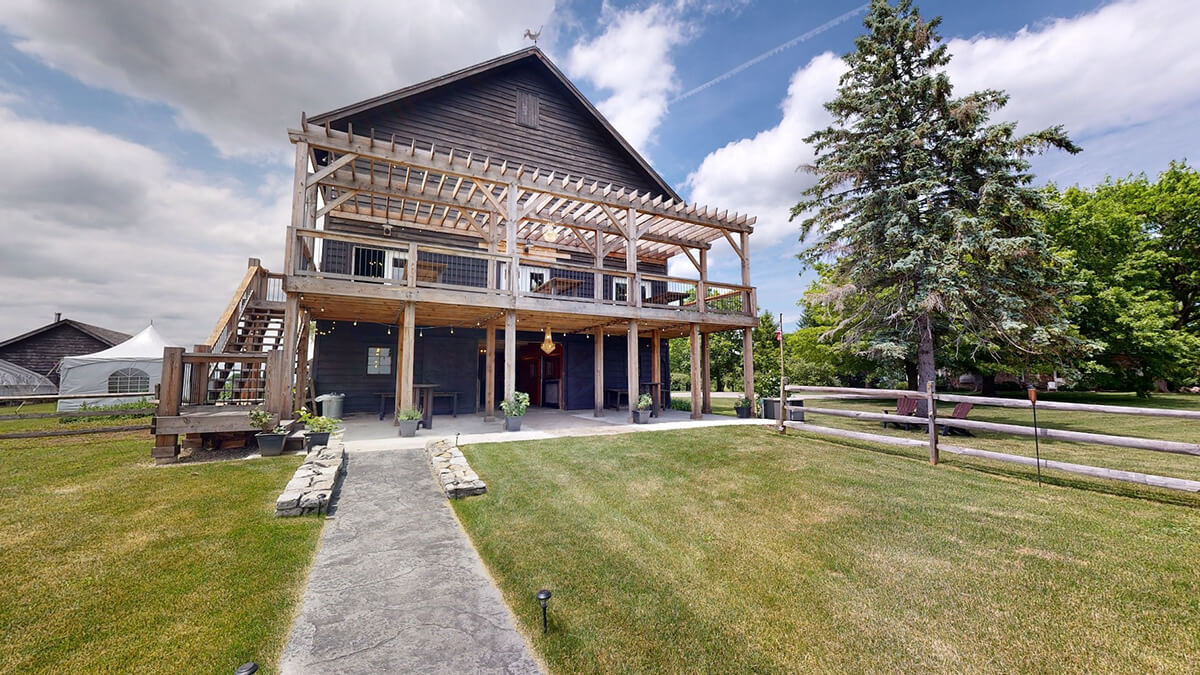 Large rustic barn deck overlooking wedding venue.